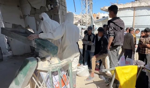 Gazze'de açlık çeken Filistinliler, ellerinde kalan bakliyat ve hububatları öğüterek ekmek yapıyor