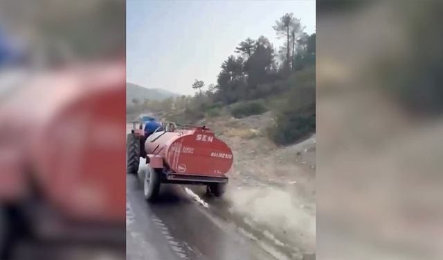 Bursa'da bir çiftçi, patlayan lastiğe rağmen yangına su taşıdı