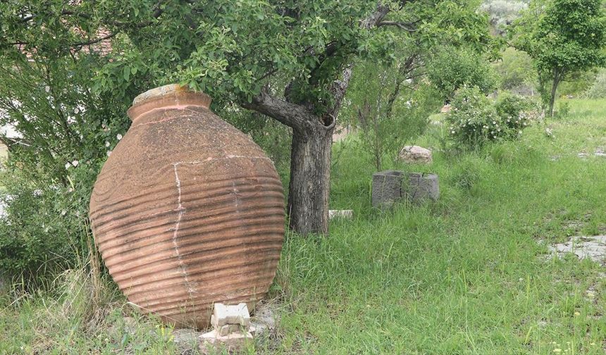 Köydeki kültürevinin bahçesini eski küp ve steller süslüyor